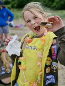A Brownie enjoys a snack on the beach.